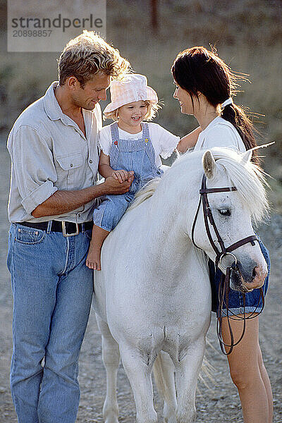 Family outdoors. Child's pony ride.