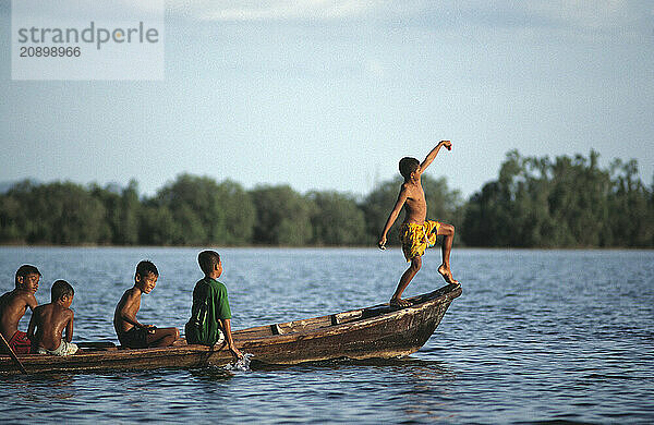 Thailand. Phang Nga. Boys in a boat. Pretending to be in the Royal Barge.