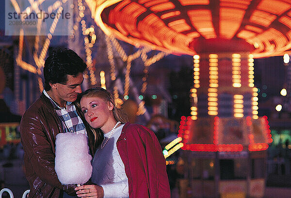 Young couple in fairground amusement park.