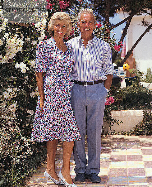 Older couple. Outdoors in hotel garden. Mediterranean.