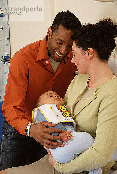 Family. Father & Mother holding baby boy in hospital.