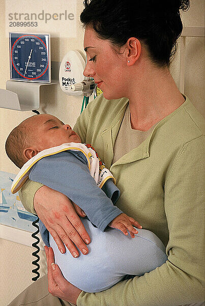 Young mother holding baby boy in hospital