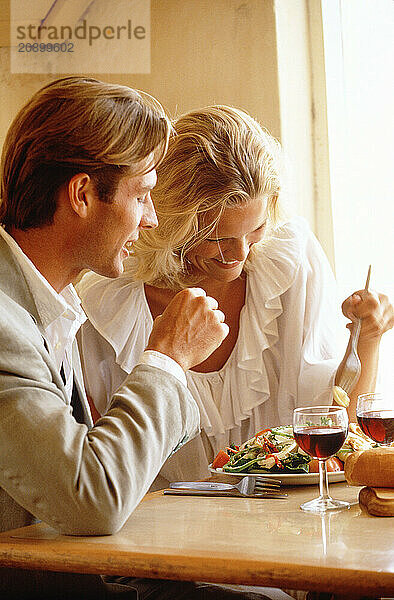 Close up of young couple dining indoors.