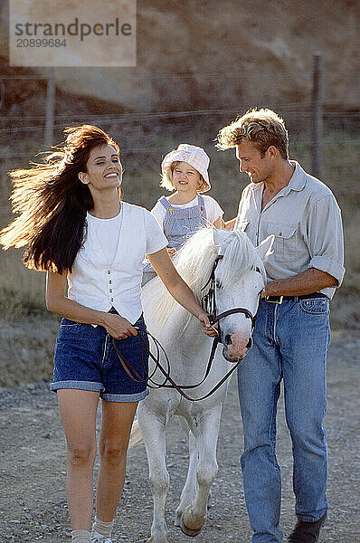 Family outdoors. Child's pony ride.