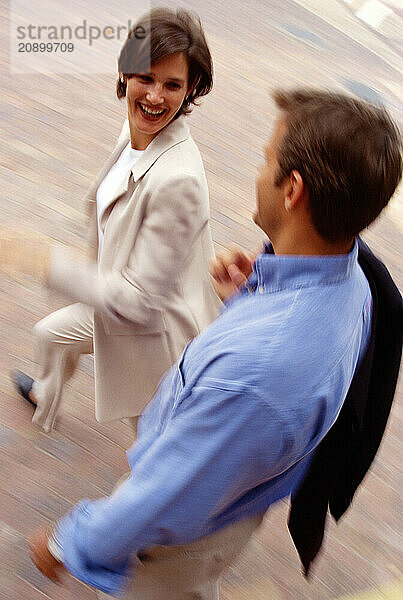 Young man & woman running outdoors in city. Motion impression.