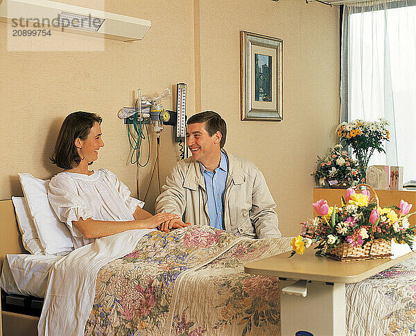 Hospital. Man visiting woman patient in private room.