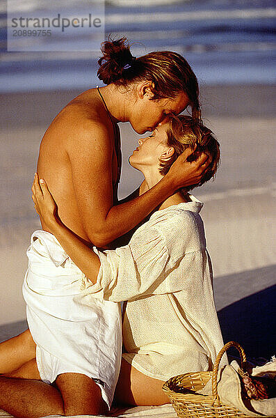 Young couple embracing at the beach.