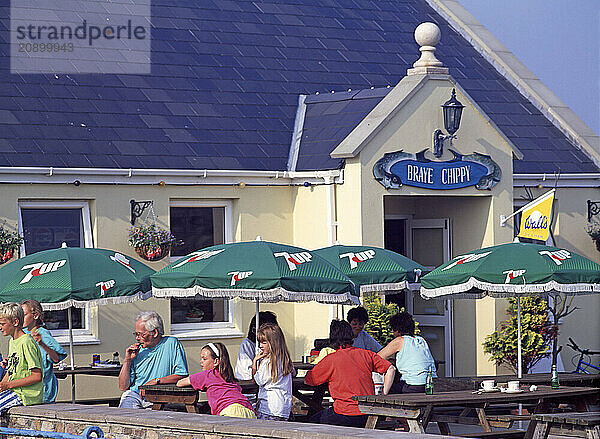 Channel Islands. Alderney. People sitting on terrace of the Braye Chippy restaurant.