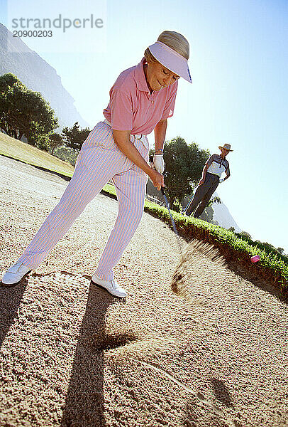 Retirement age couple playing golf.