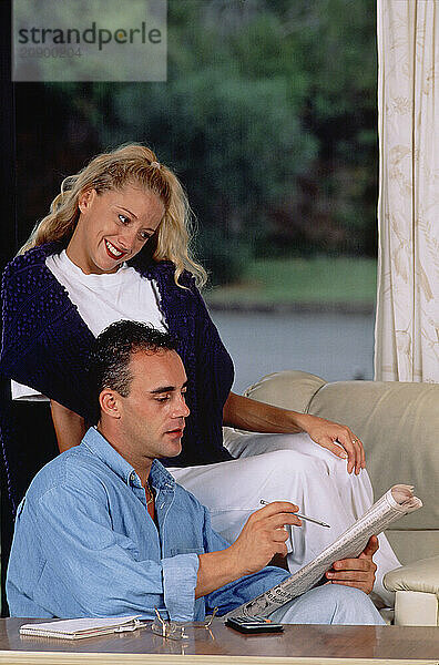 Young couple indoors at home sitting in lounge room.