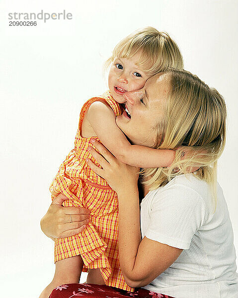 Mother hugging little girl child.