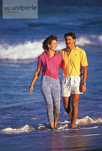 Couple walking in the sea at the beach.