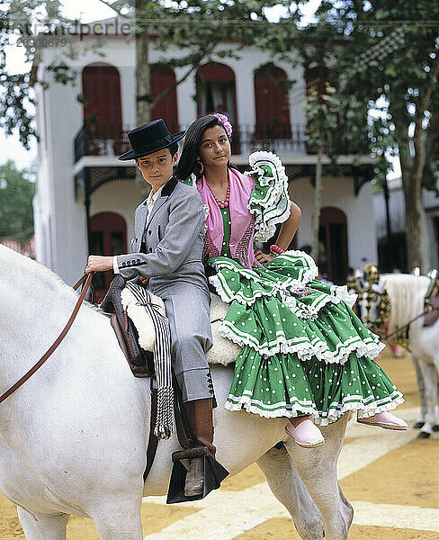 Spain. Andalusia. The Jerez Horse Fair. Children in costumes on horse back.