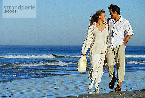 Young couple walking on the beach.