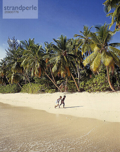 Seychelles. Mahé. Takamaka. Local children on the beach.