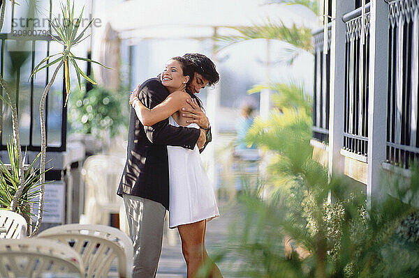 Young couple embracing in restaurant conservatory.