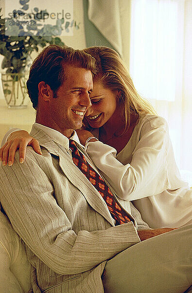 Young couple sitting together indoors.