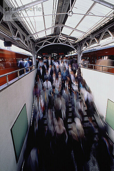 Japan. Tokyo. Commuters descending stairway at Kanda railway station.