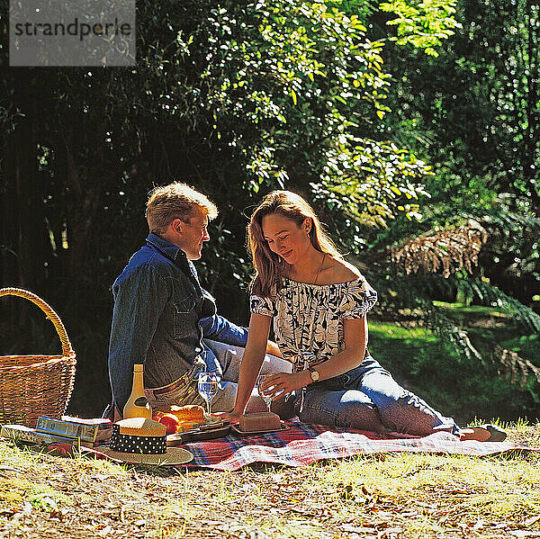 Young couple outdoors picnic in the park.