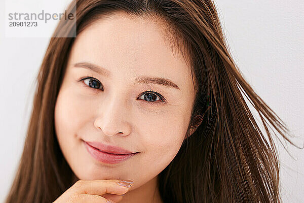 Asian Woman With Long Brown Hair Posing For The Camera