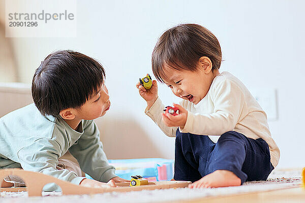 Happy Japanese kids playing on the floor