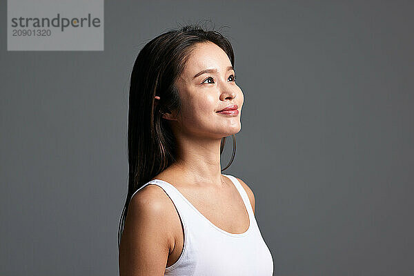 Asian Woman In White Tank Top Looking Up