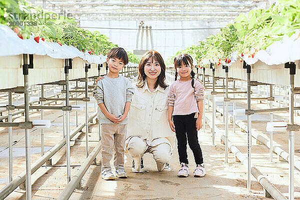 Asian woman and children in a greenhouse