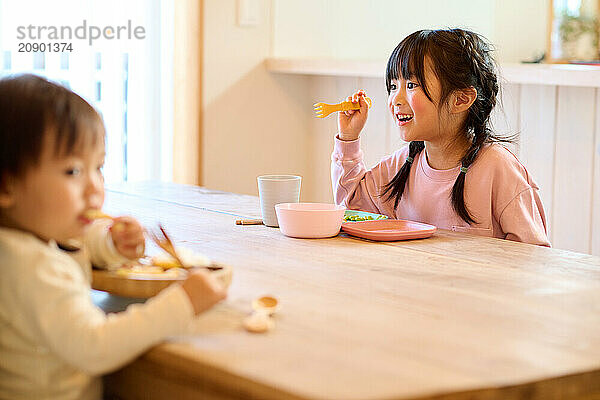 Asian children eating at a table