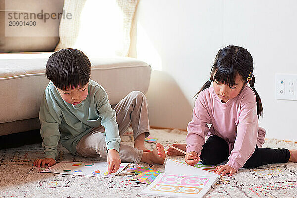 Happy Japanese kids playing on the floor