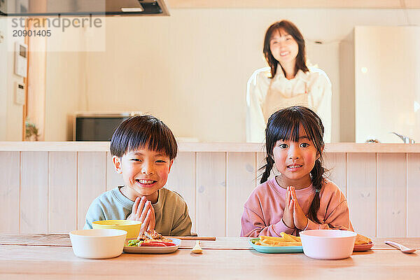 Happy Japanese kids eating in the dining room