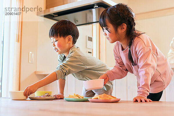 Happy Japanese kids eating in the dining room