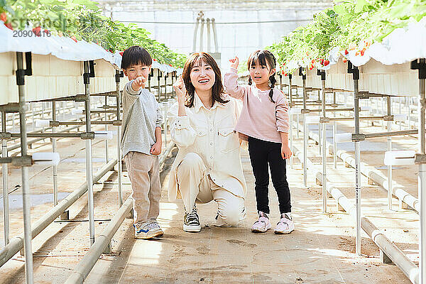 Asian woman and children in a greenhouse