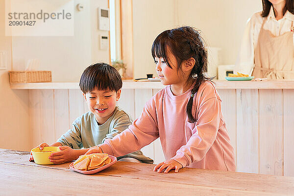 Happy Japanese kids eating in the dining room