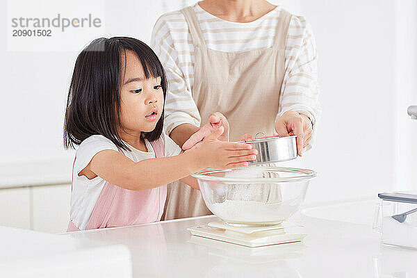 Asian woman and child mixing something in a bowl