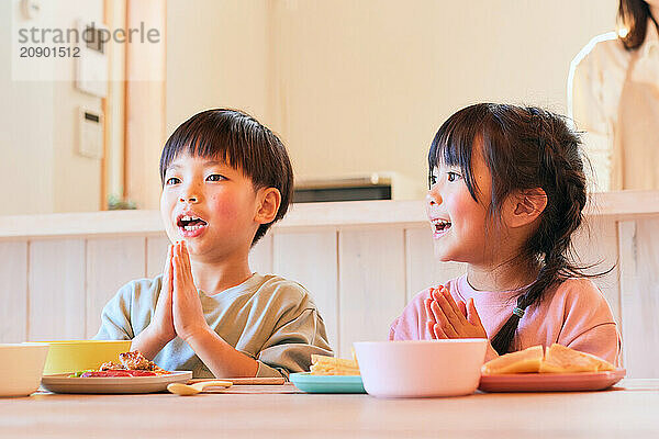 Happy Japanese kids eating in the dining room