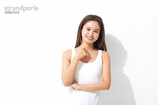 Asian Woman In A White Tank Top Posing For The Camera