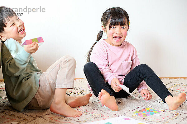 Asian children sitting on the floor playing with toys