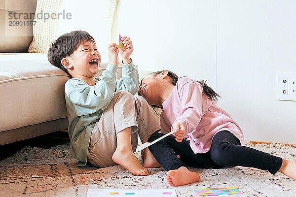 Happy Japanese kids playing on the floor