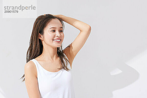 Asian Woman In A White Tank Top Smiling