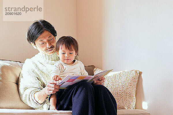 Japanese father and son reading a book