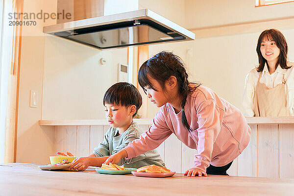 Happy Japanese kids eating in the dining room