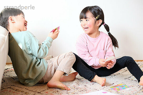 Asian children sitting on the floor playing with toys