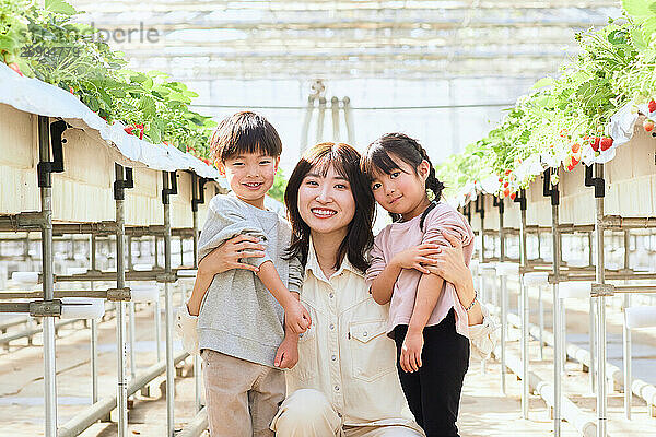 Asian woman and children in a greenhouse