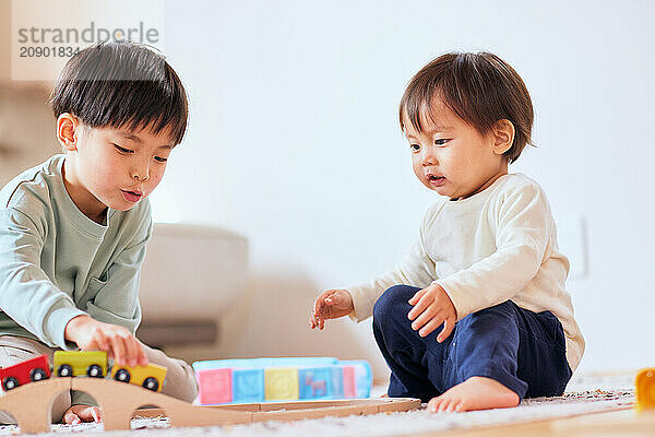 Happy Japanese kids playing on the floor