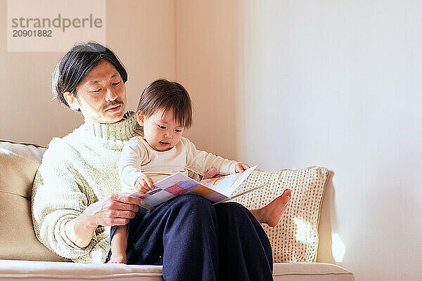 Japanese father and son reading a book