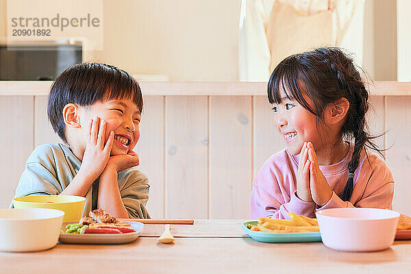 Happy Japanese kids eating in the dining room