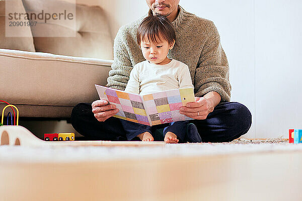 Japanese father and son reading a book