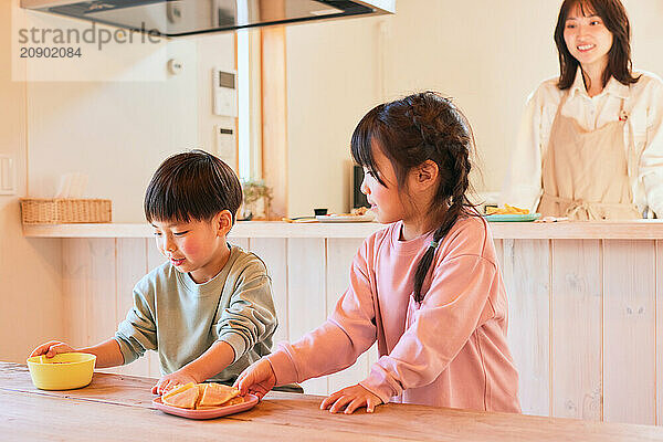 Happy Japanese kids eating in the dining room