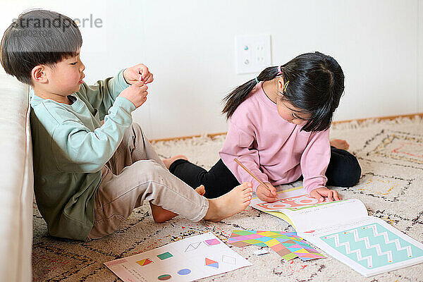 Asian children sitting on the floor with their books