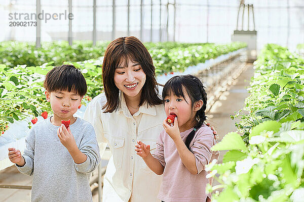 Asian woman and children in a greenhouse